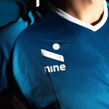 Majice collection featuring a close-up of the logo on a blue sports jersey.
