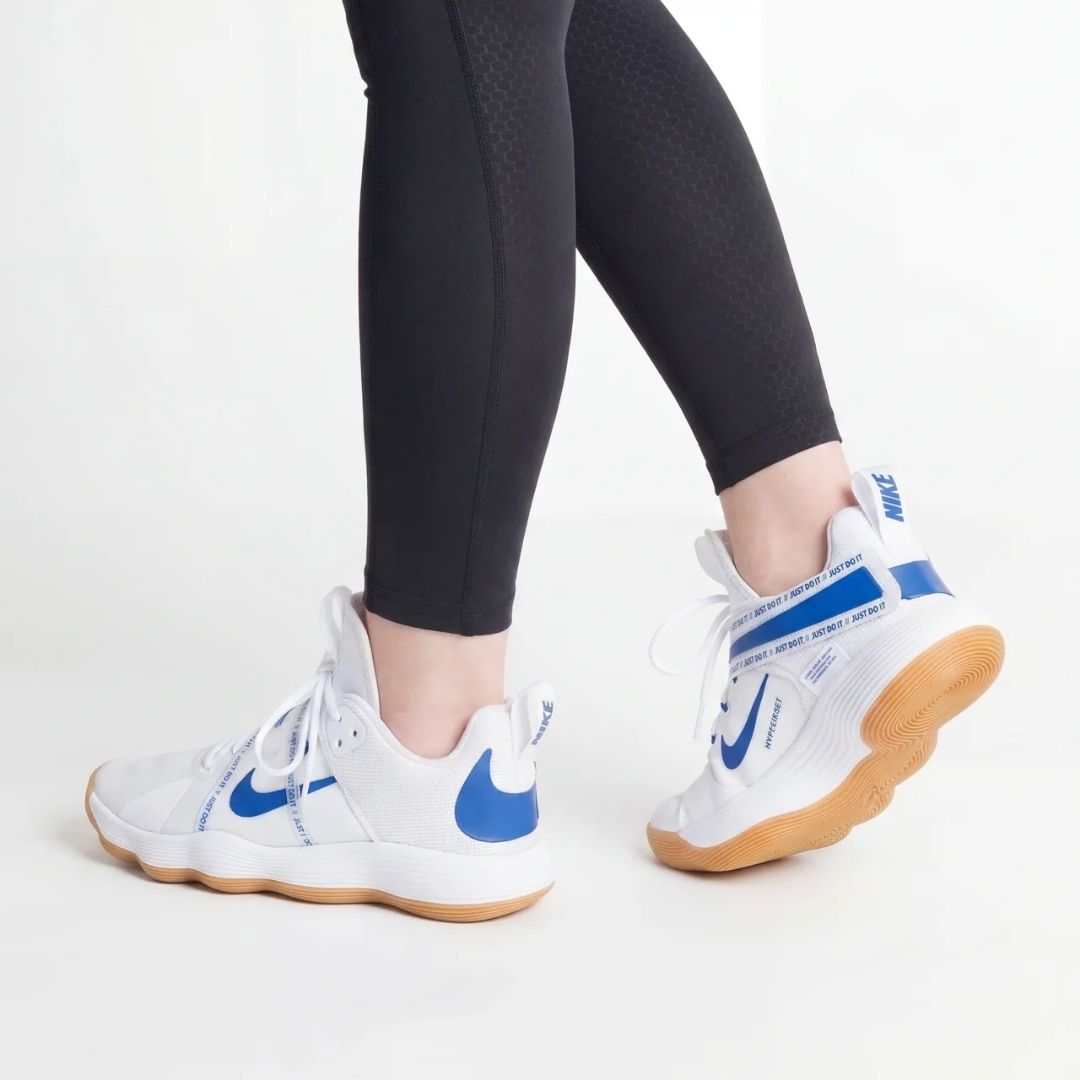 Moški Nike React Hyperset odbojkarski copati s plavimi detajli na belih podplatih.