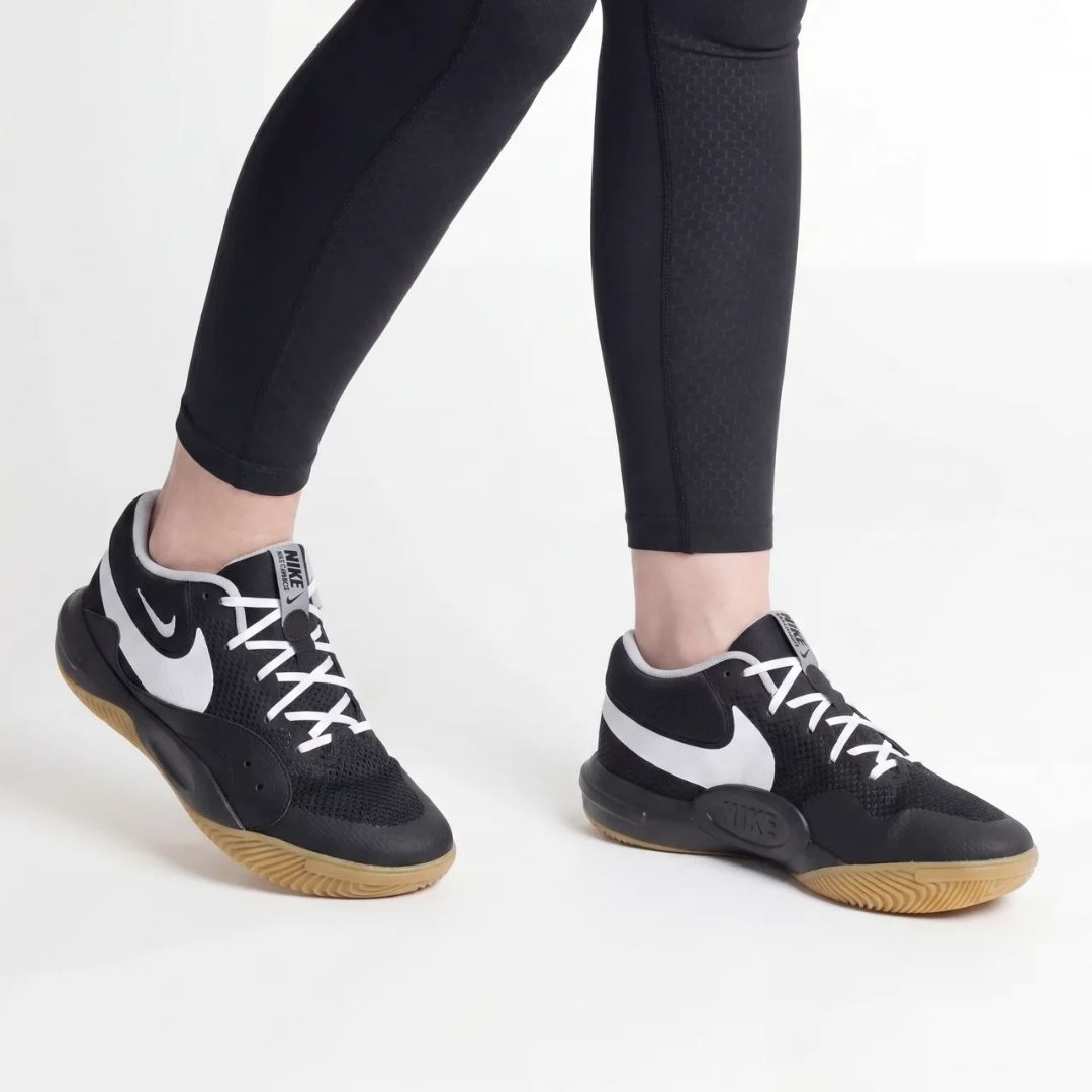 Nike Hyperquick črne, odbojkarski copati za hitrost in okretnost, prikazani na športniku v črni opremi.